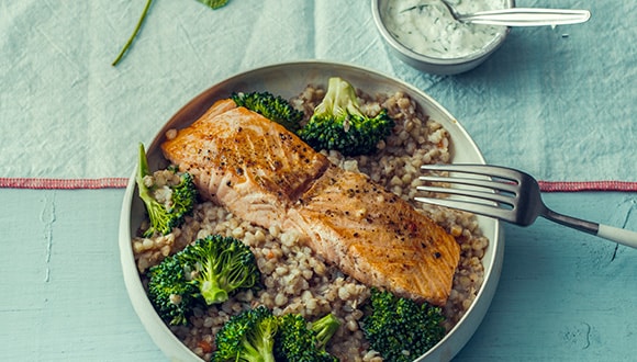 Meal full of protein, featuring salmon, greens and rice.