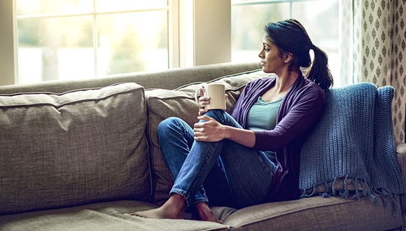 woman on sofa looking out a window