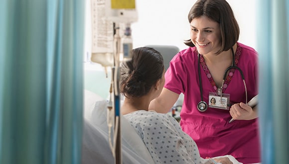 A woman in hospital for endometriosis surgery, speaking with her doctor