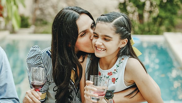 woman with wine glass holding a child