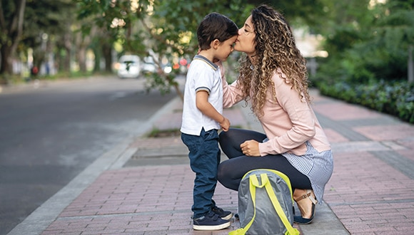 Co-parenting with an alcoholic partner: mother kisses young son on the forehead