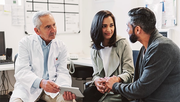 A couple speaking to their doctor about infertility treatments available to them.