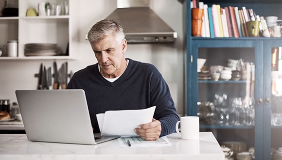 Man on laptop paying bills