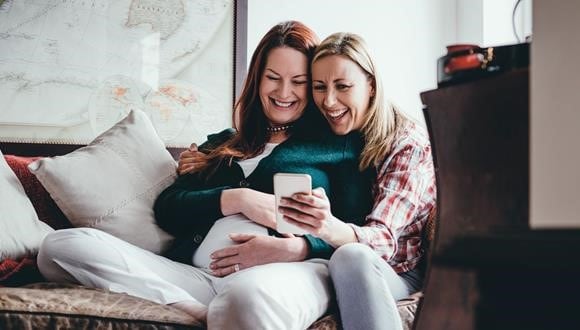 Parents-to-be lying on the couch as they talk about how they’ll be preparing for labour.  