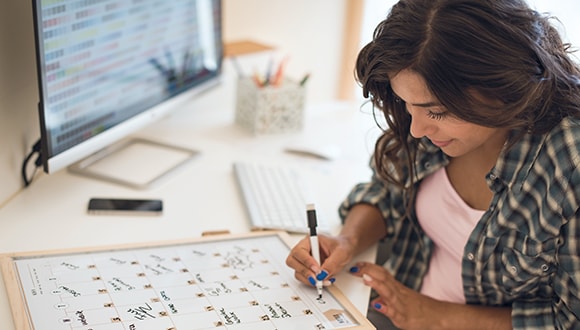 Woman ticking off her new year's resolutions on a calendar