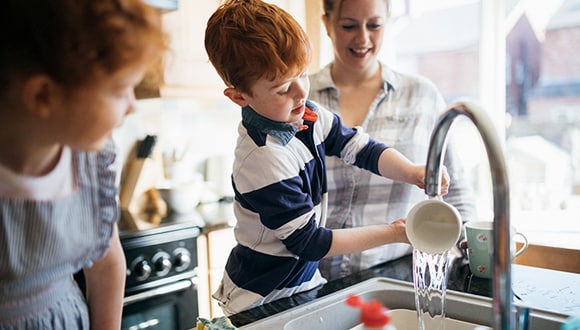 A boy is washing dishes