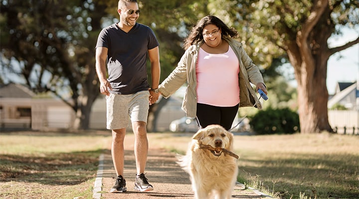 A man and a woman walking with dog