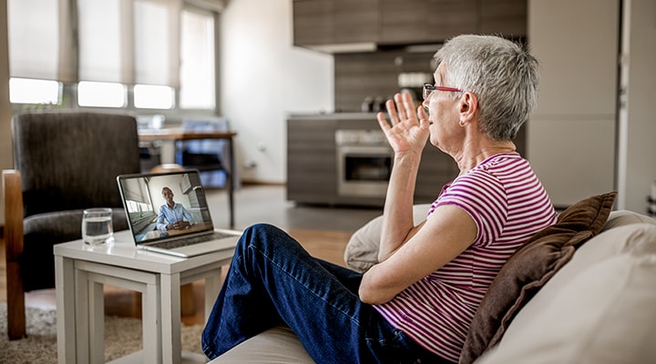 Telehealth services have been effective during COVID-19: Woman sitting on a couch chatting through video.