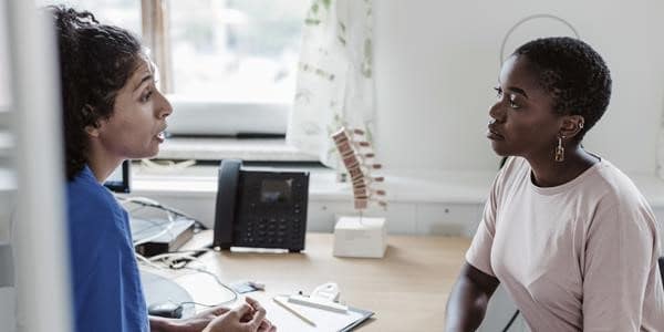 Woman with doctor learning about what hormones are